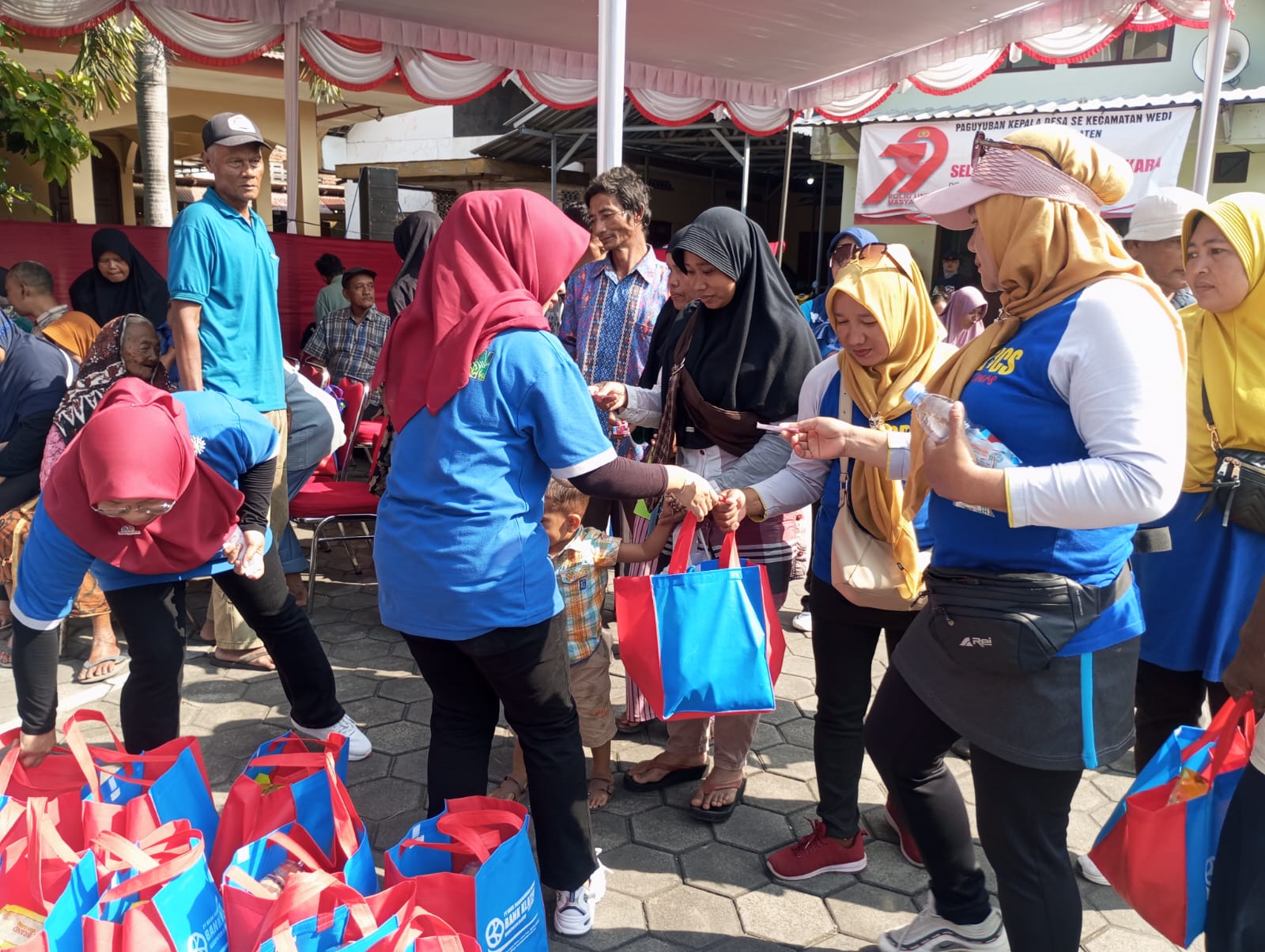 Petugas Bank Klaten membagikan sembako kepada Masyarakat dalam rangkaian HUT Bank Klaten ke-74. Dok. Pribadi.