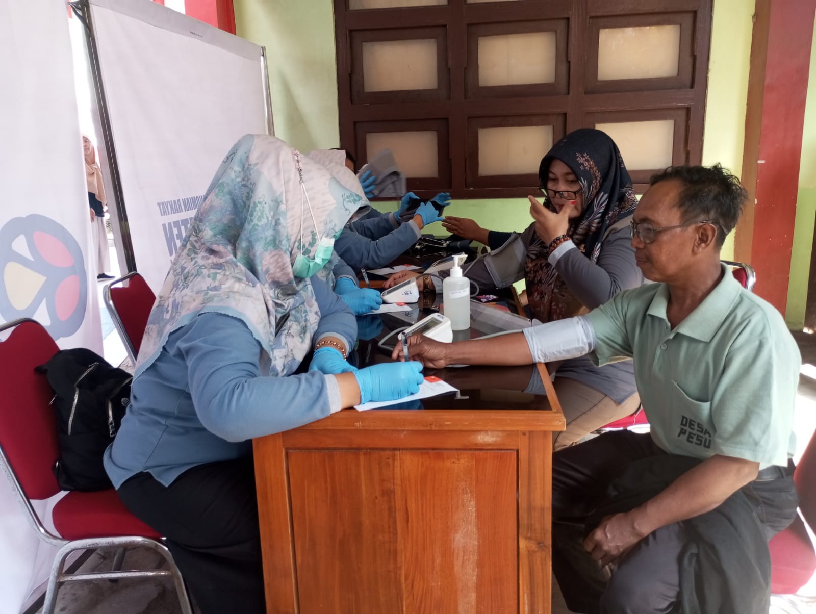 Tim kesehatan dari Puskesmas Wedi melakukan cek kesehatan kepada masyarakat dalam rangkaian acara HUT Bank Klaten. Dok. Pribadi